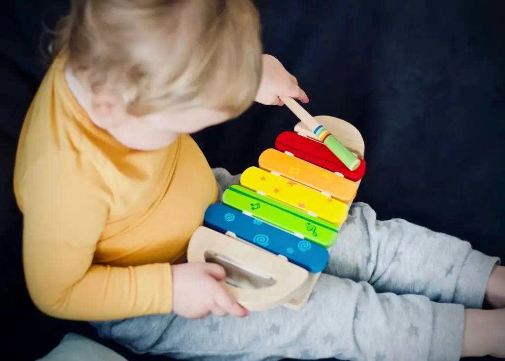 Encouraging learning through play with a parent guiding a toddler in fun educational activities at home Encouraging learning through play as a toddler explores hands-on educational games at home